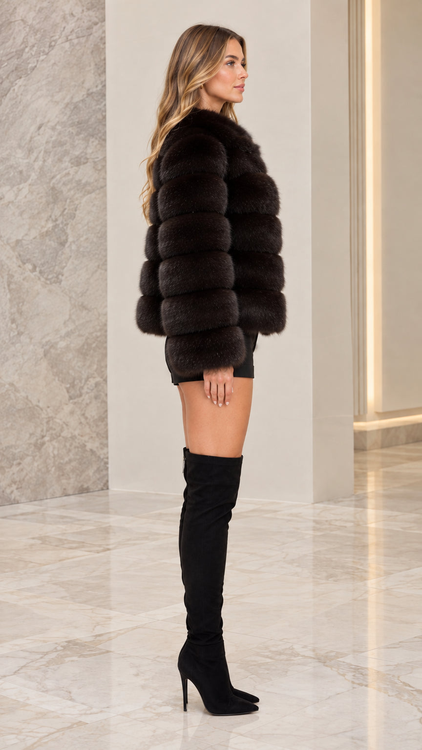 Side profile view of model wearing black ribbed faux fur coat