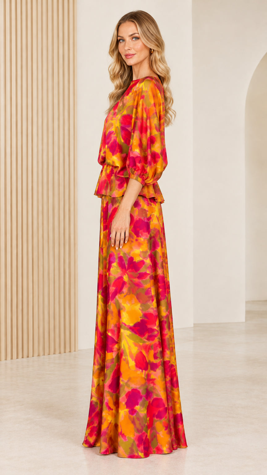 Side profile view of woman modeling vibrant orange floral puff sleeve maxi gown