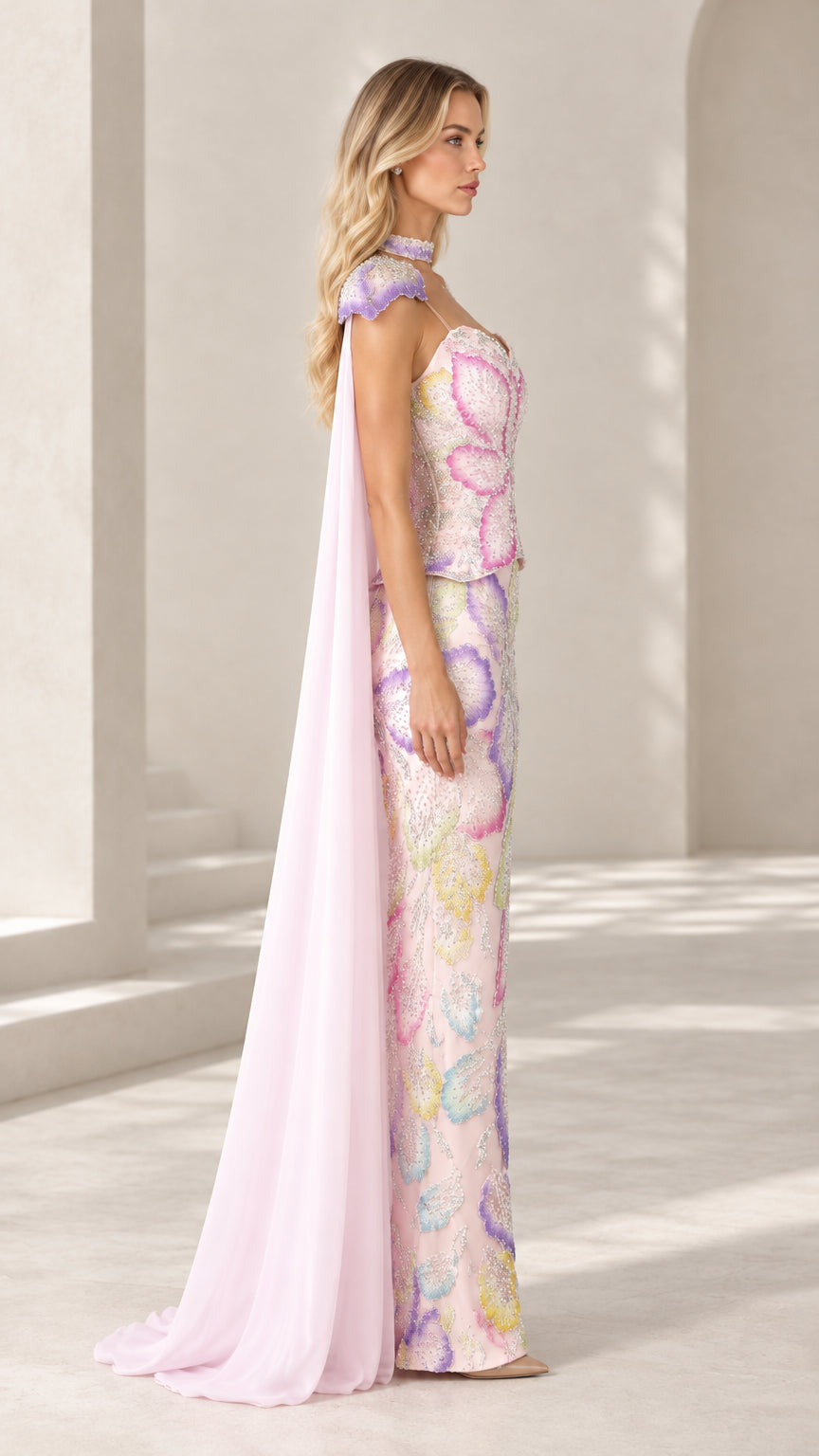 Side profile view of light pink beaded column maxi dress with chiffon cape