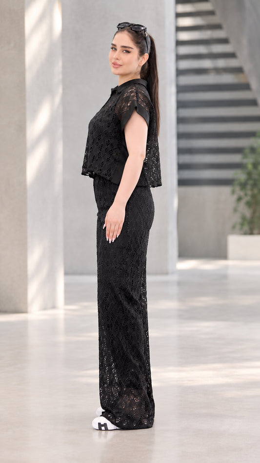 Side profile view of black lace two-piece top and wide-leg trousers set