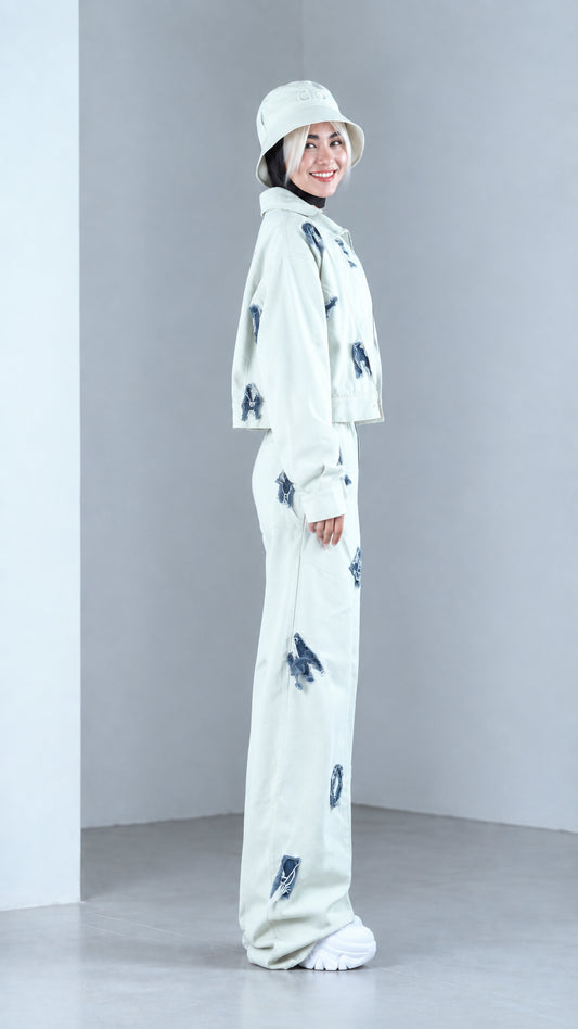 Side view of woman posing in mint green two-piece jacket and wide-leg streetwear set