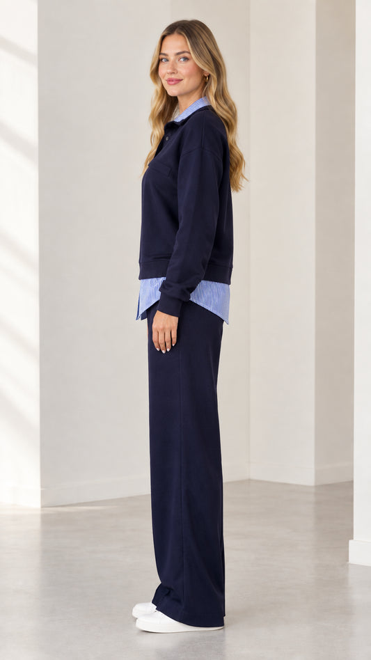 Side profile view of navy blue layered sweatshirt and wide leg trousers set