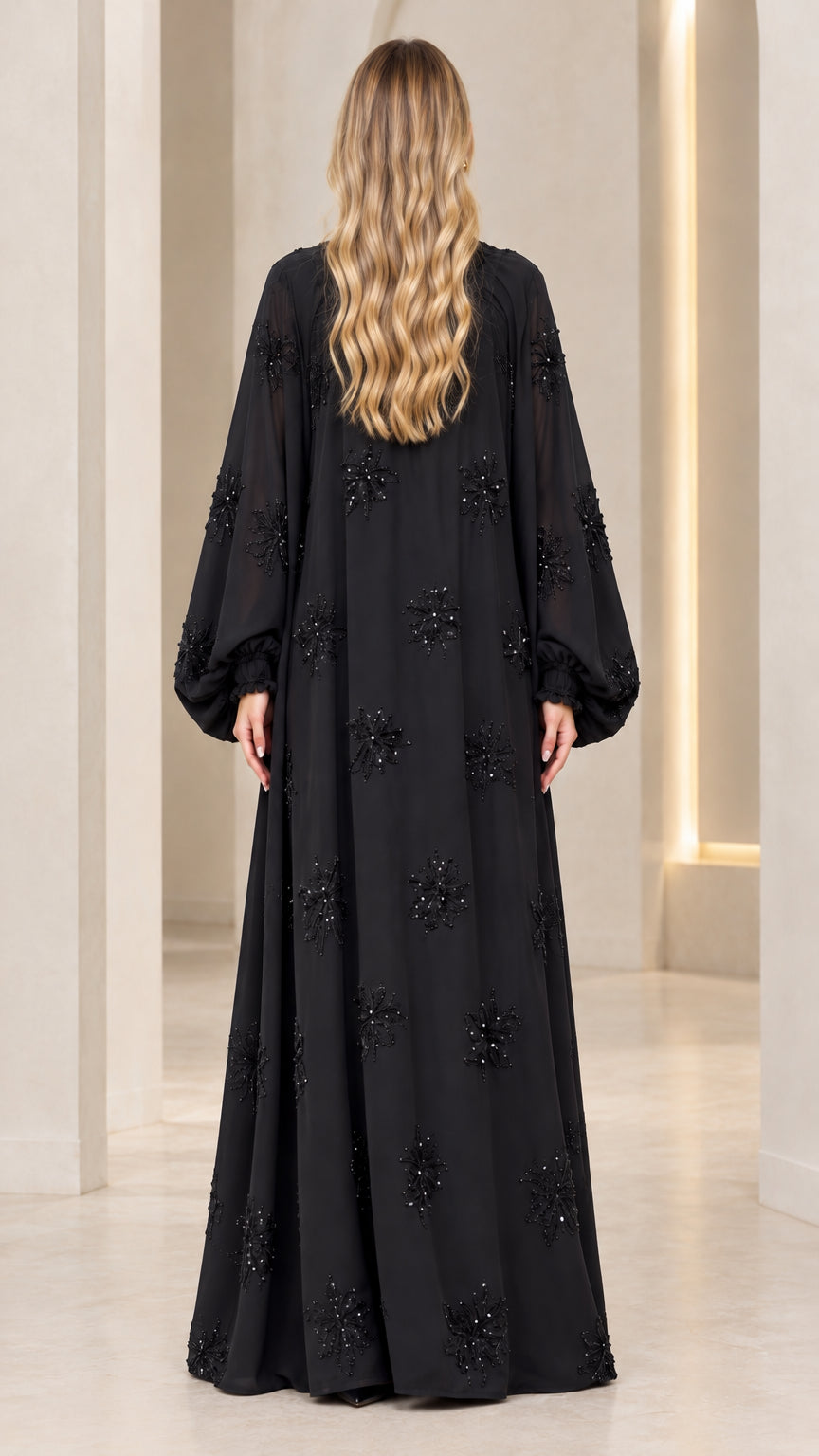 Back full-length view of black beaded flowy evening maxi dress