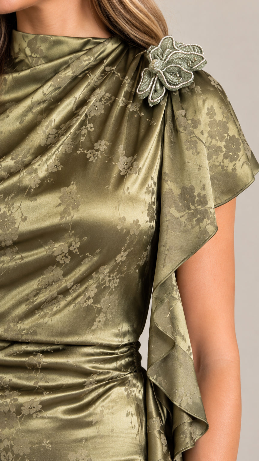 Close-up detail of draped neckline, shoulder floral appliqué, and satin jacquard texture