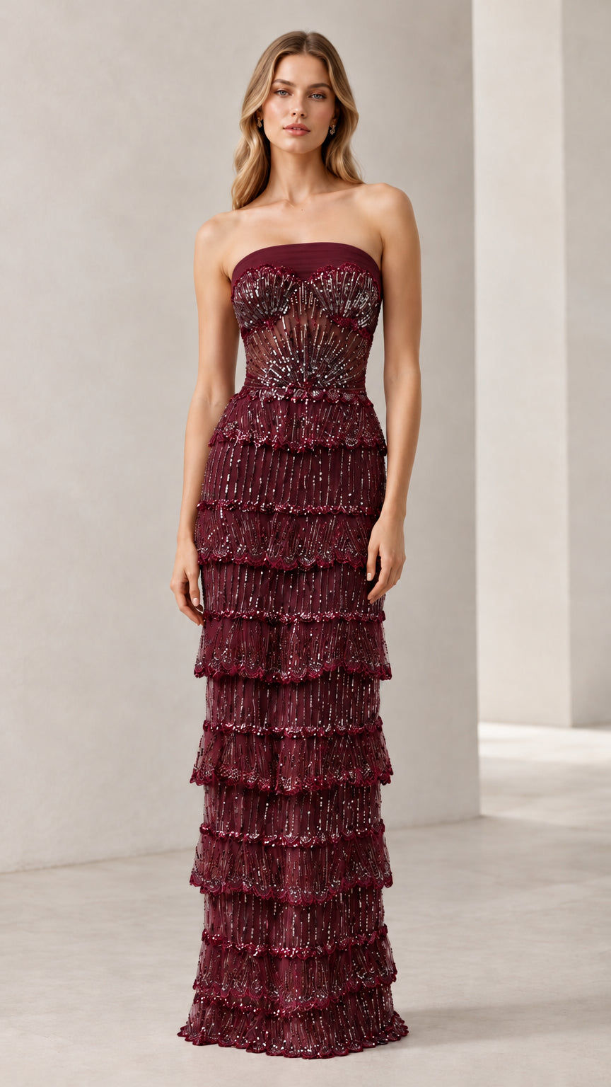 Full-length view of woman wearing burgundy strapless beaded tiered evening gown