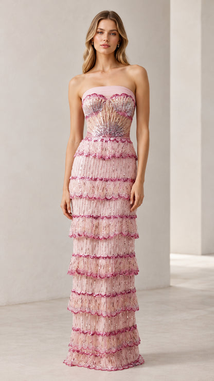 Front full view of woman wearing strapless blush pink beaded tiered column evening gown