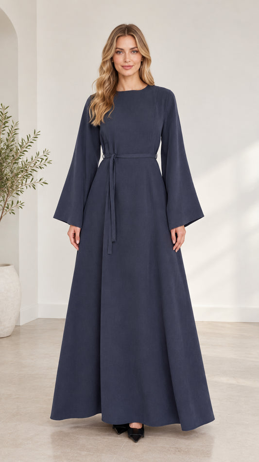 Full front view of woman wearing navy blue long bell sleeve modest maxi dress with waist tie