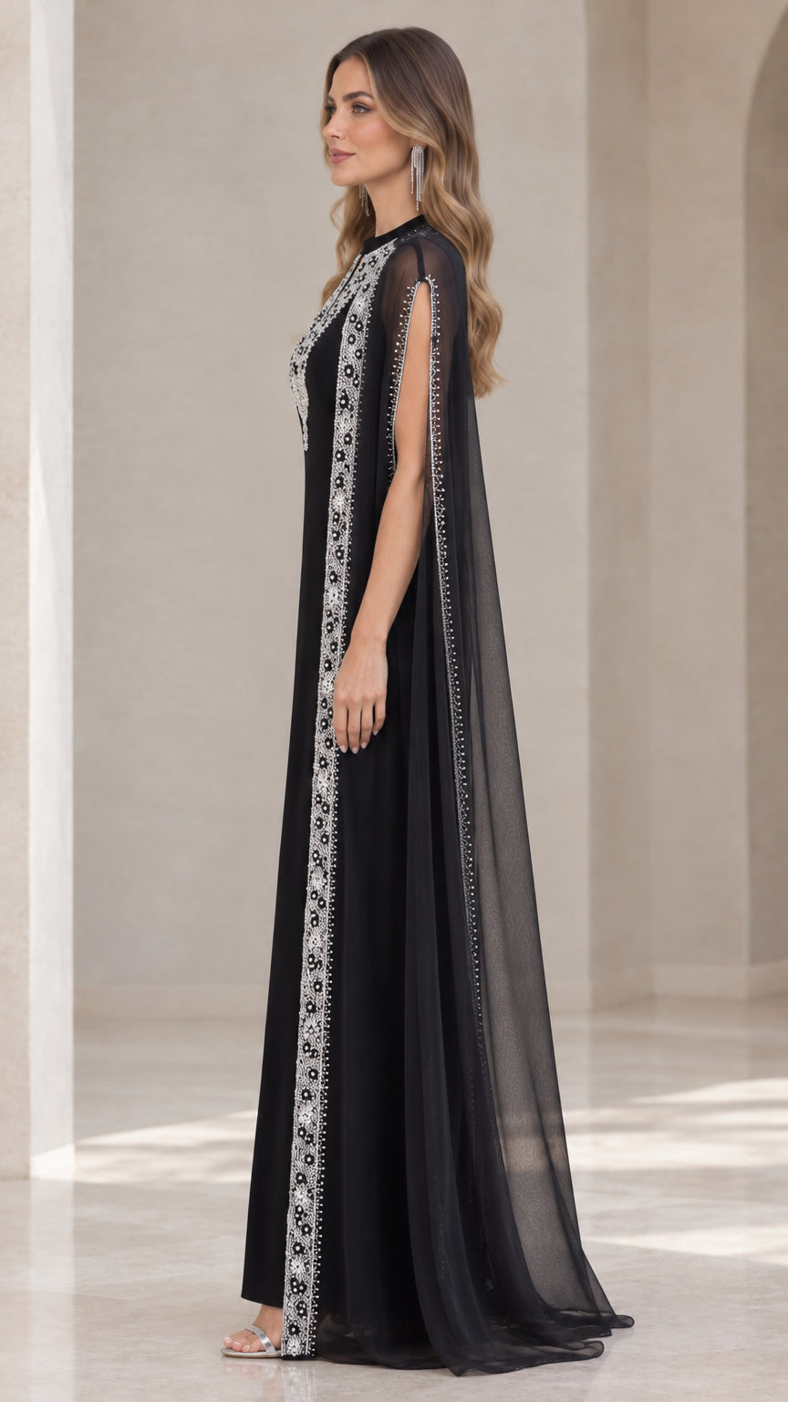 Side profile view of black floor-length cape maxi dress showing arm slit details