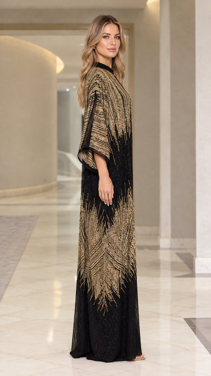Side profile view of woman modeling black and gold sequin evening kaftan