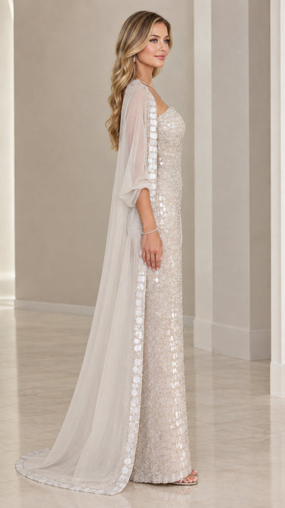 Side profile of champagne embellished evening gown with flowing chiffon cape