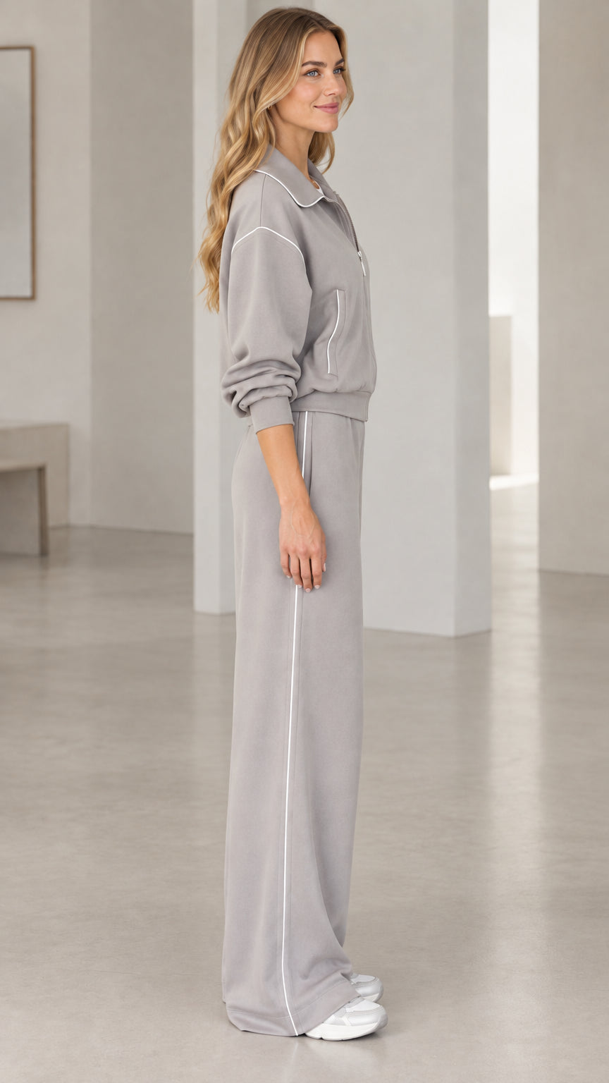 Side profile view of model wearing Heather Grey loungewear set with white side piping