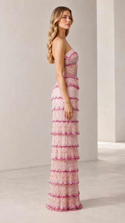 Side profile view of woman wearing strapless blush pink beaded tiered maxi gown