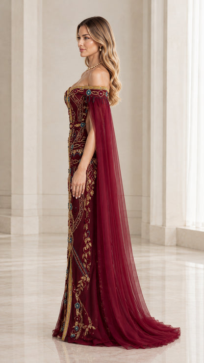 Side profile view of woman wearing burgundy embroidered cape maxi dress