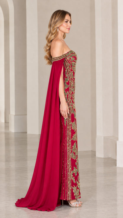 Side profile of burgundy formal gown showing floor-length cape sleeve drape