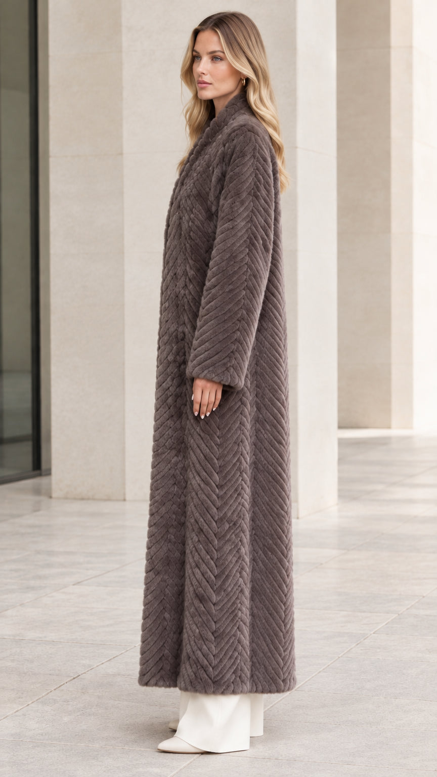 Side profile of model wearing longline charcoal grey faux fur overcoat