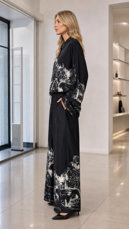 Side profile view of black sketch print two-piece shirt and wide-leg trousers outfit