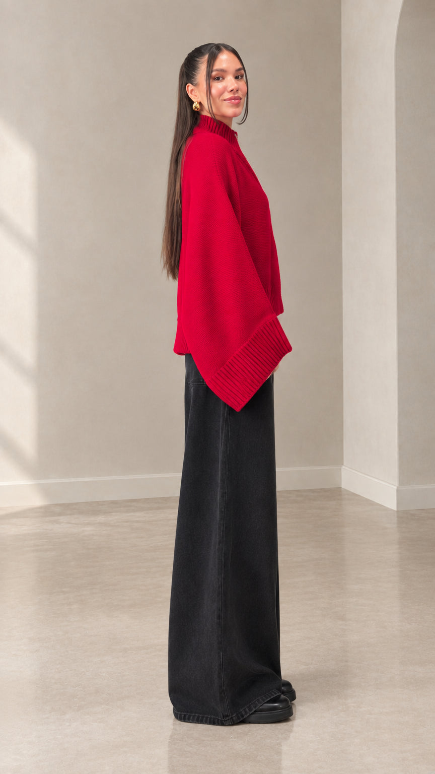 Side view of woman wearing red batwing sleeve knit sweater
