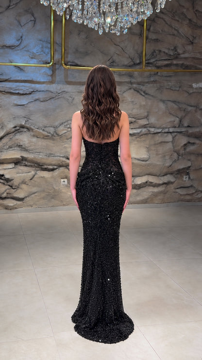 Back view of model in open-back black sequin mermaid evening gown