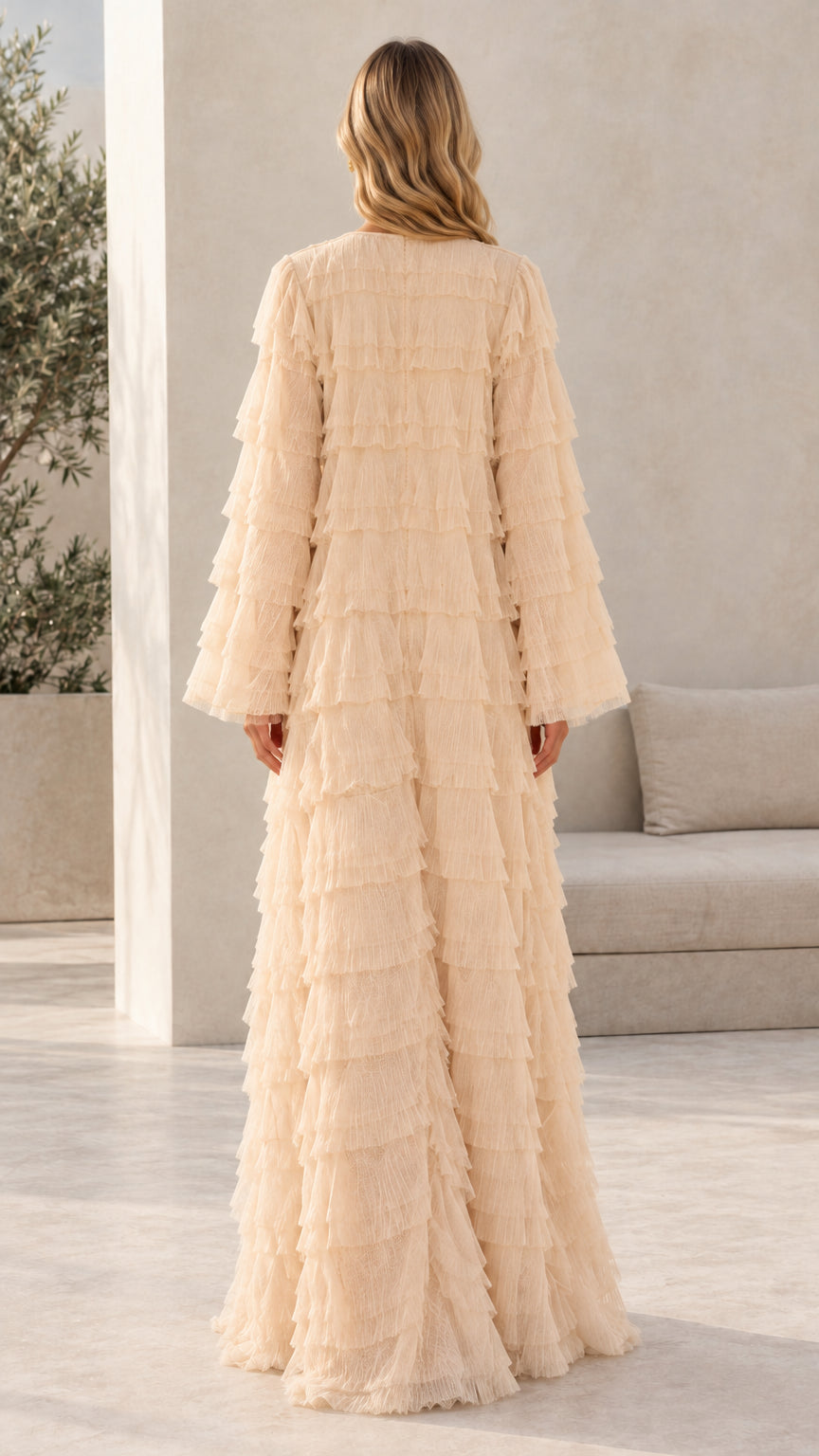 Model wearing champagne tiered fringe floor-length dress back view