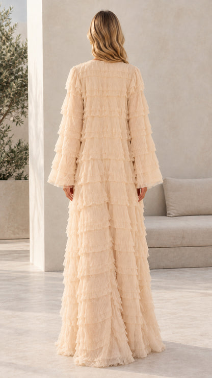 Model wearing champagne tiered fringe floor-length dress back view