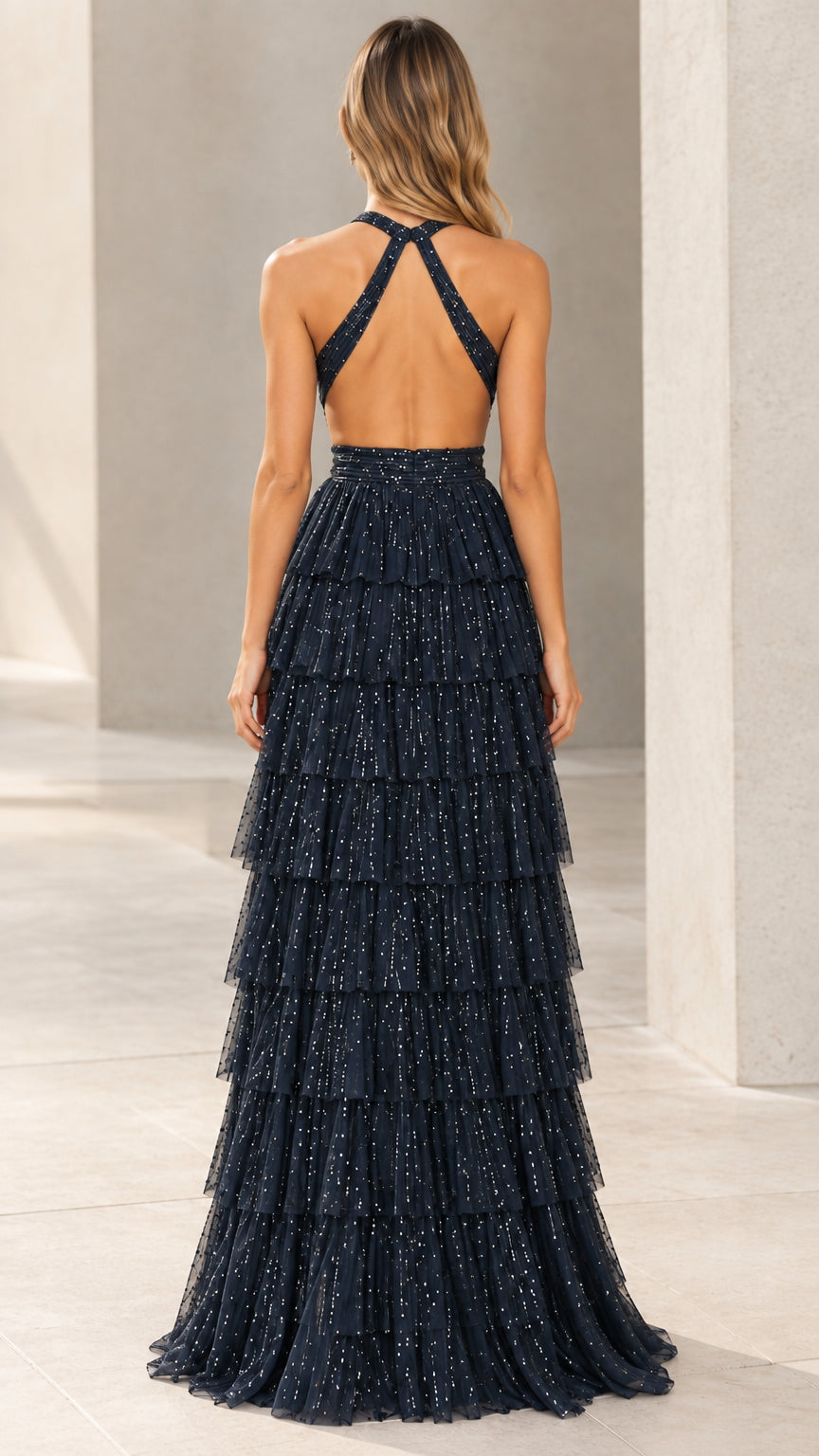 Back view of navy blue glitter maxi gown featuring cross straps and open back