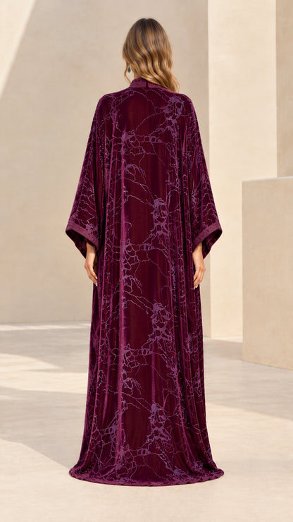 Back full-length view of flowing plum velvet kaftan with floral embroidery