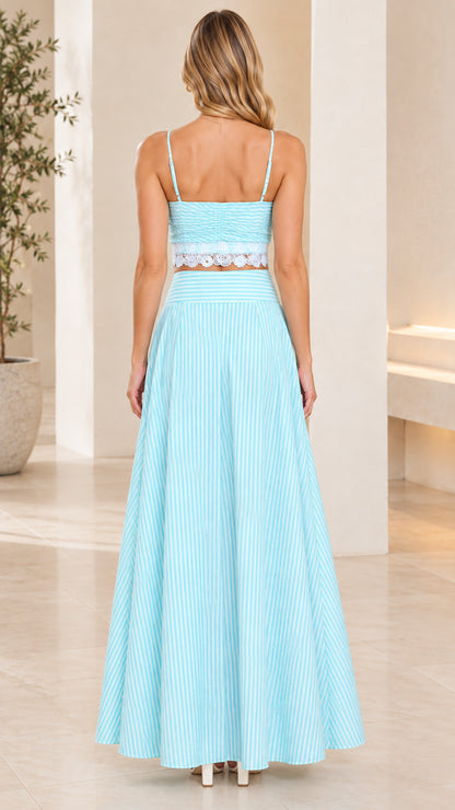 Back view of model wearing sky blue striped crop cami and pleated skirt set