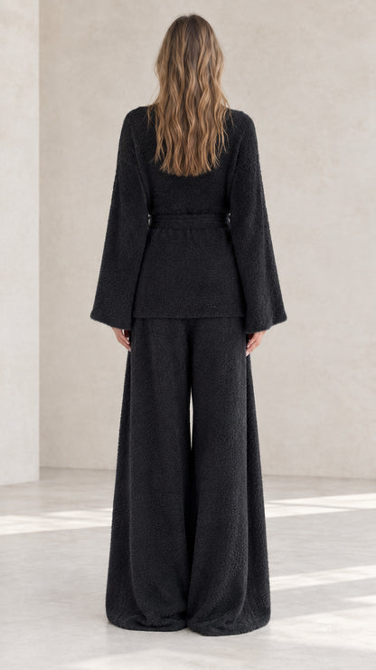 Black plush knit lounge set back view showing drape of wide leg pants