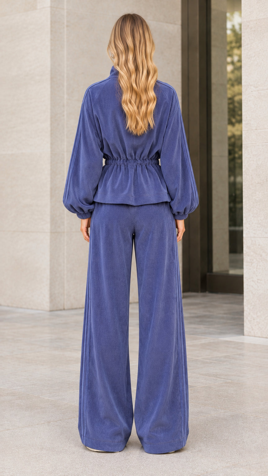 Back view of woman wearing slate blue corduroy cinched waist tracksuit