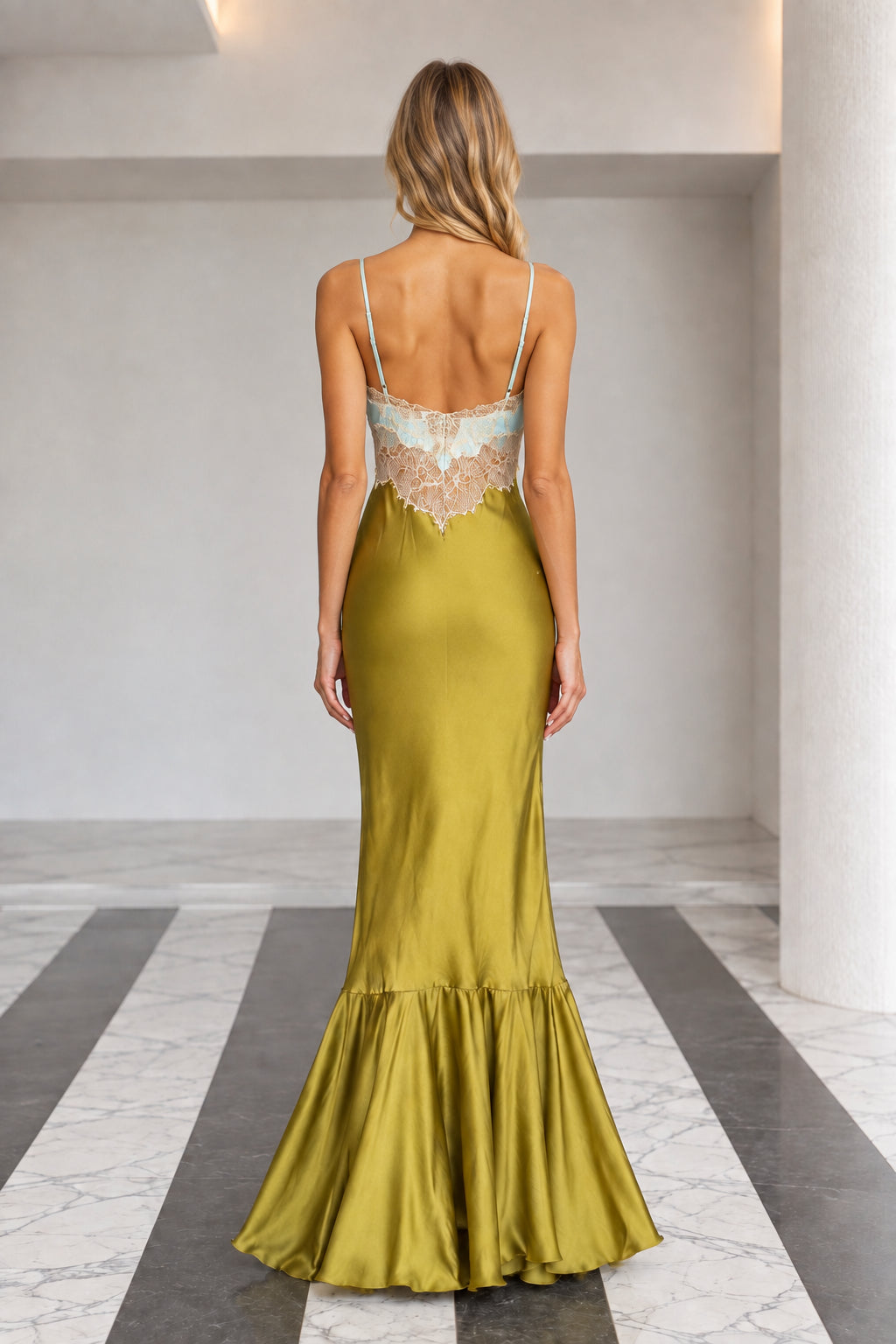 Back view of olive green satin slip maxi dress with thin straps and ruffled hem