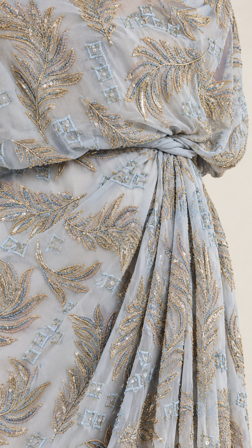 Close-up detail of metallic leaf embroidery and gathered draped waistline