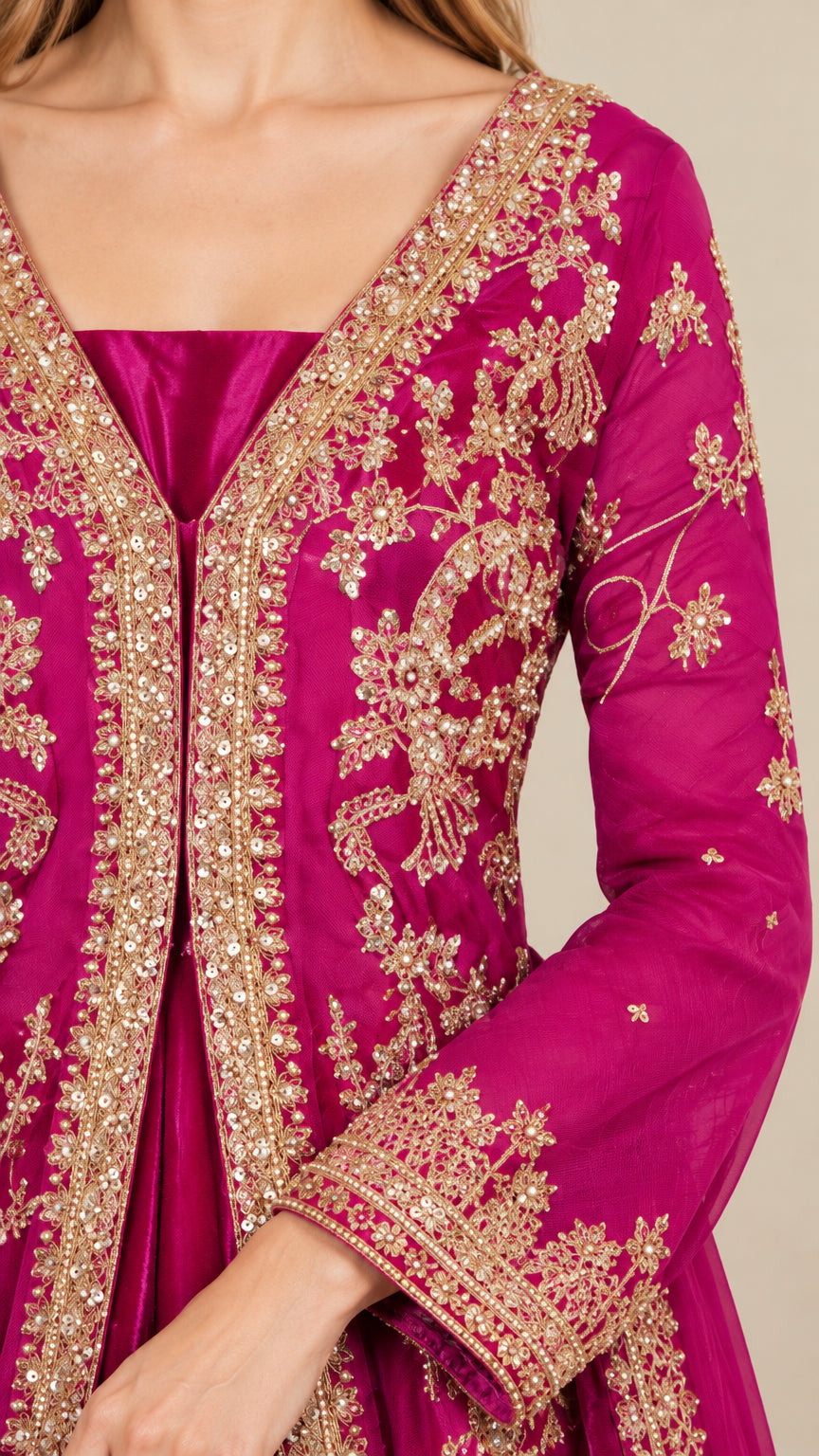 Close-up detail of golden floral embroidery and neckline on magenta evening gown