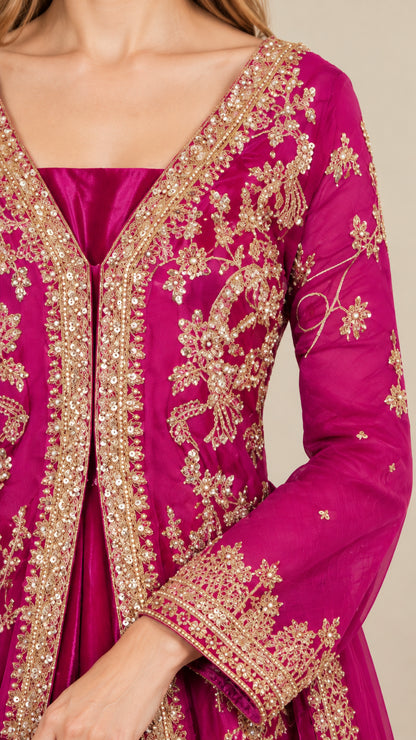 Close-up detail of golden floral embroidery and neckline on magenta evening gown
