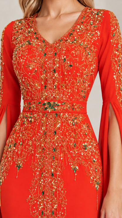 Close-up detail of ornate gold and emerald beading on the bodice and V-neckline of the red gown