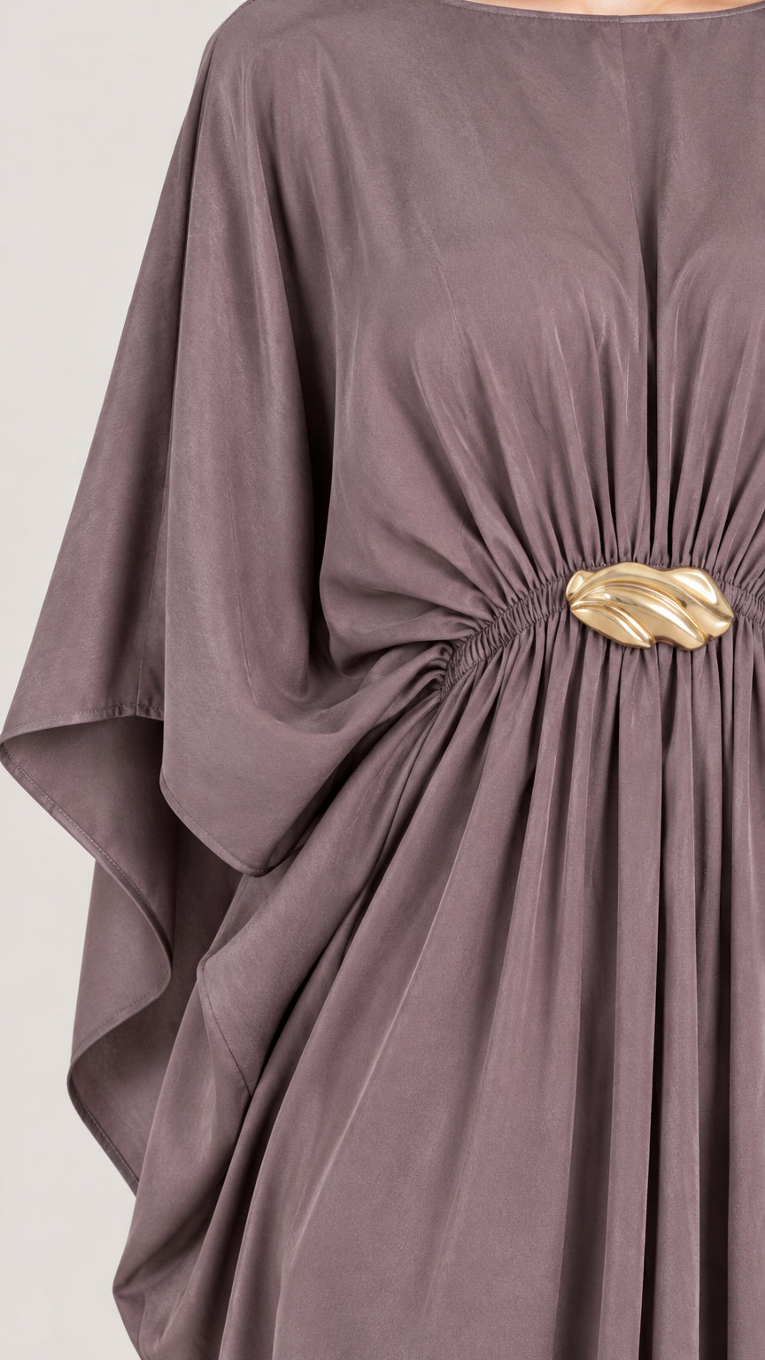 Close-up detail of the gathered waist and gold-tone buckle on mauve draped dress