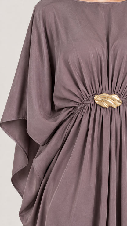 Close-up detail of the gathered waist and gold-tone buckle on mauve draped dress
