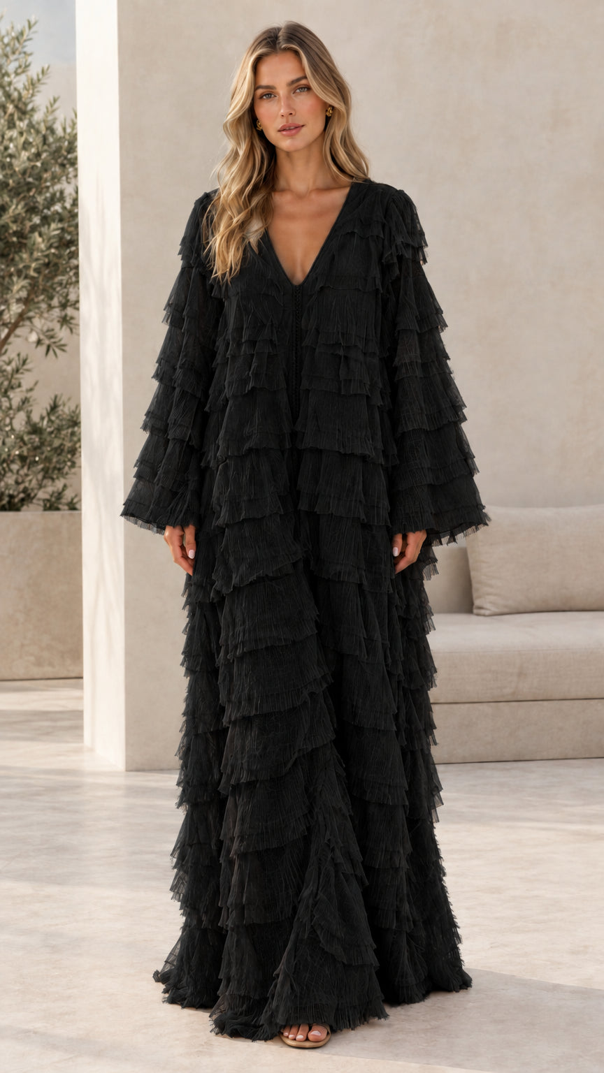 Model wearing black tiered fringe long sleeve maxi kaftan dress