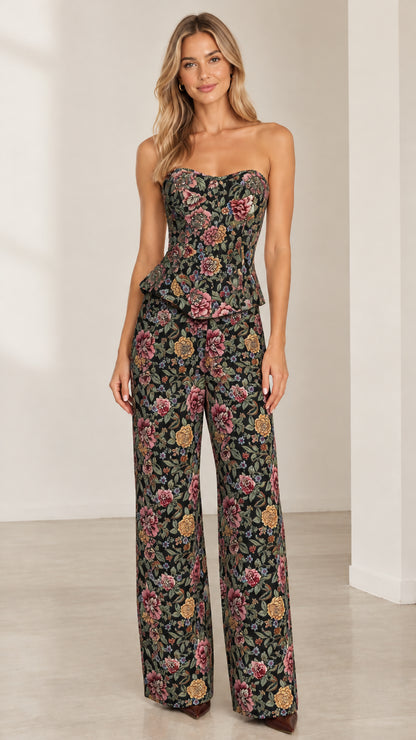 Full front view of model wearing black floral tapestry strapless peplum top and wide-leg pants set