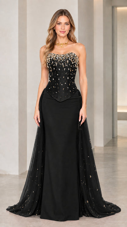 Model wearing black strapless beaded corset evening gown with sheer train