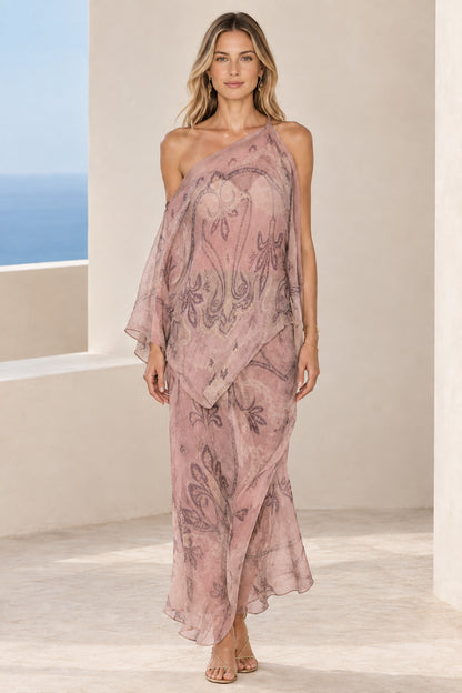 Front view of woman wearing dusty pink paisley print one-shoulder draped maxi dress