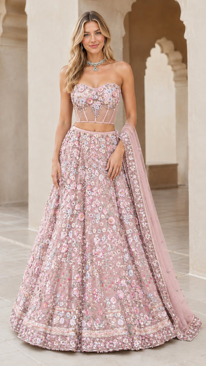 Model wearing blush pink 3D floral embroidered strapless corset lehenga set