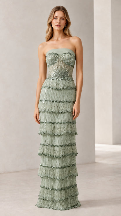 Full-length view of woman wearing sage green strapless beaded tiered evening gown