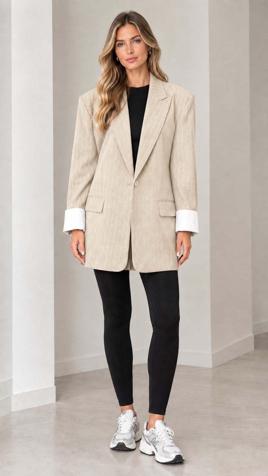 Front view of model wearing beige oatmeal pinstripe oversized blazer with white cuffs